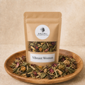 Vibrant Woman labeled kraft tea pouch on a warm herbal backdrop